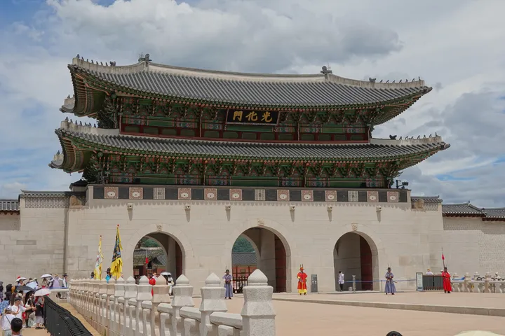Gwanghwamun, the main gate of Gyeongbokgung palace, with a few people in front of it.